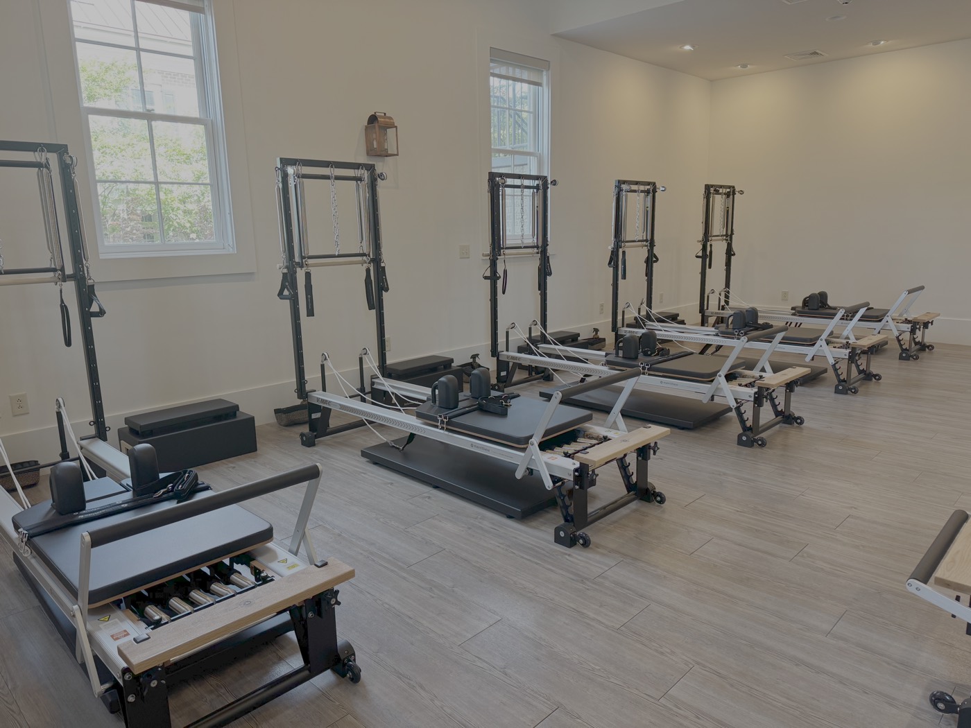 Reformer and Tower machines lined up in the Rose Pilates studio
